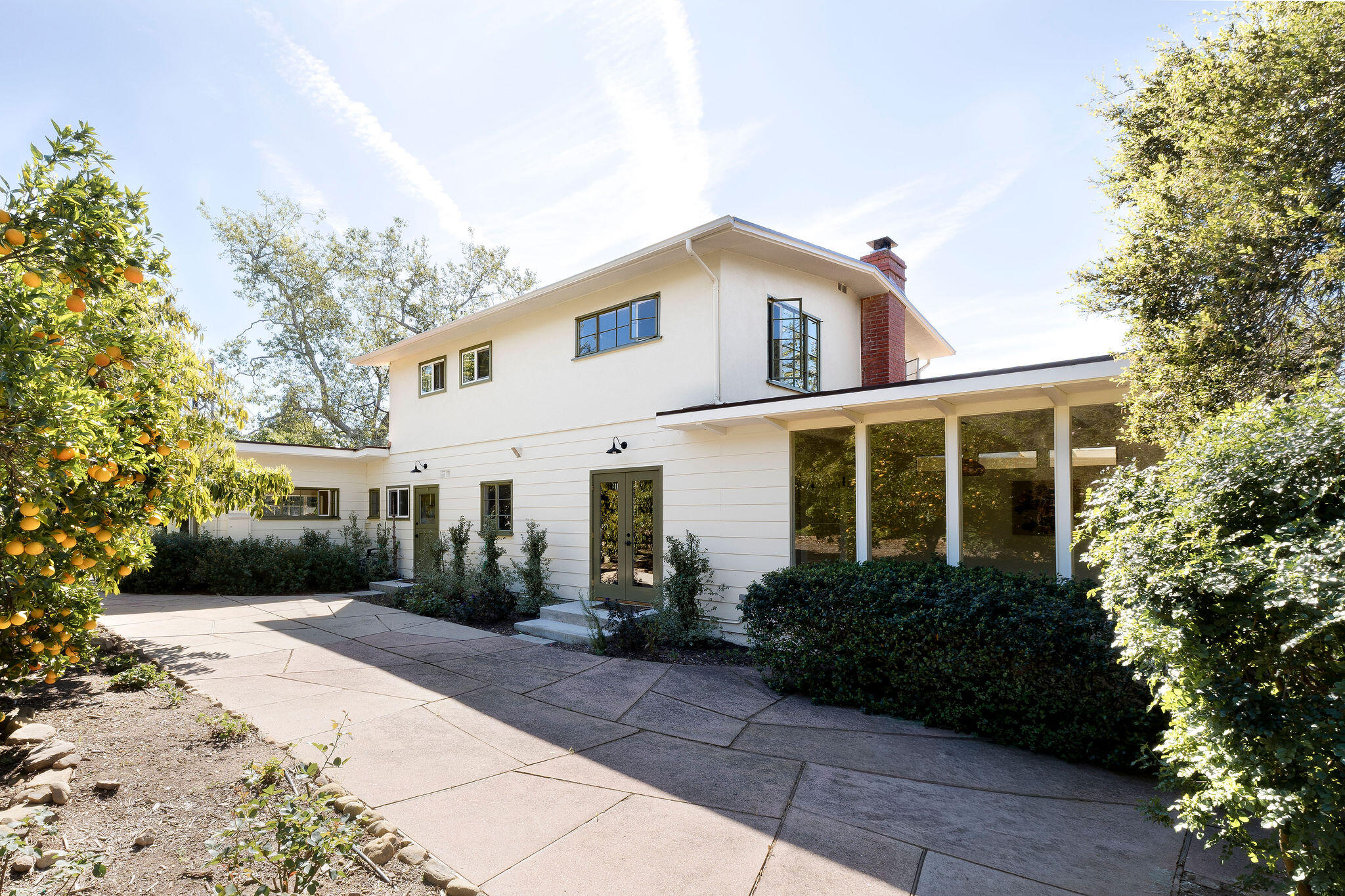 633 Tabor Lane Montecito, CA 93108 - Photo 6 of 30 a view of a white house with potted plants and a large tree