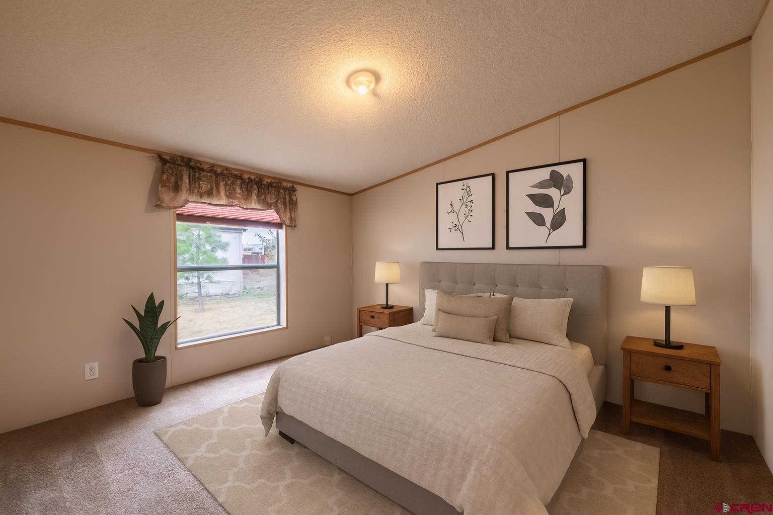 901 6530 Road, Unit 1203 Montrose, CO 81401 - Photo 15 of 22 a bedroom with a bed and a night stand