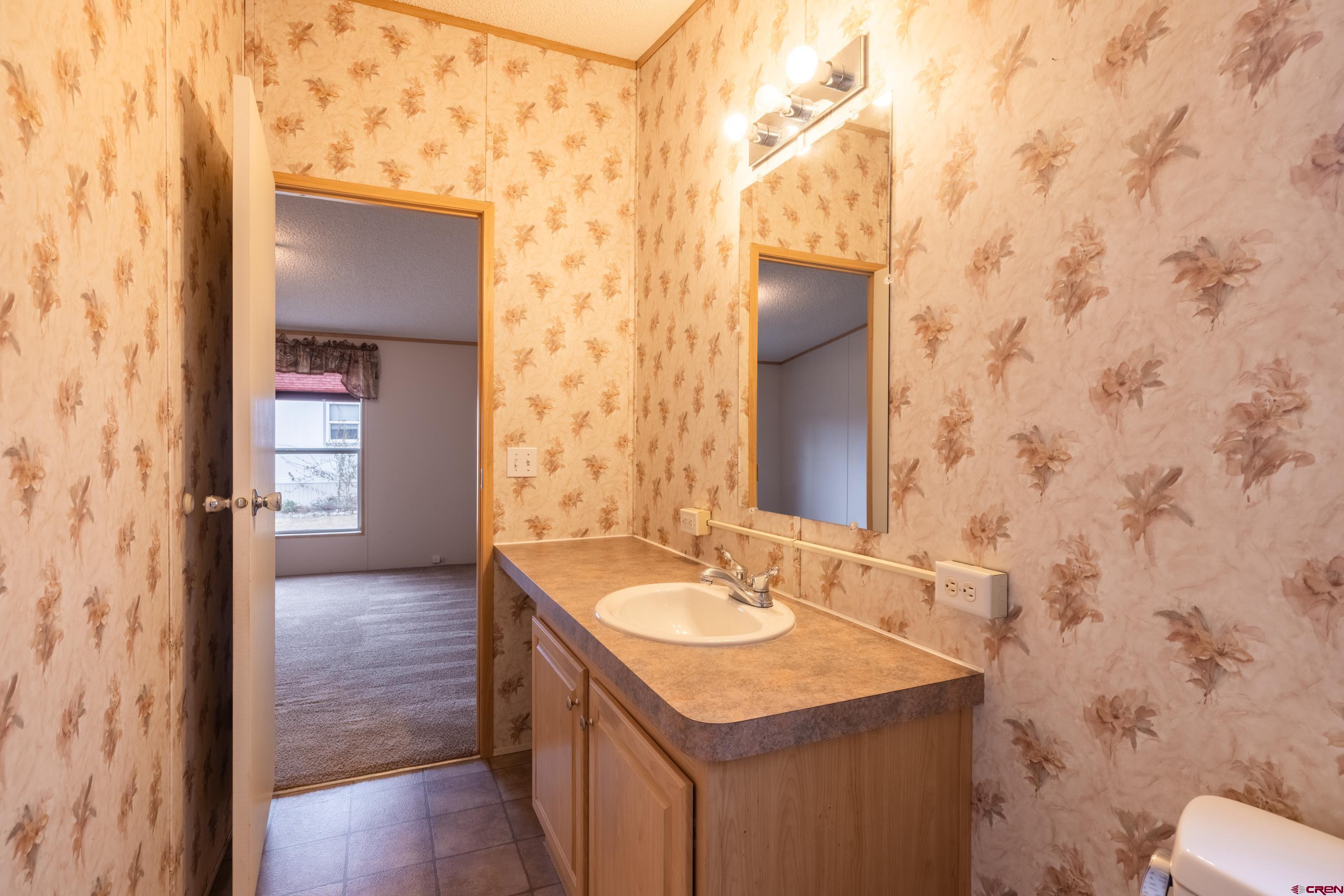 901 6530 Road, Unit 1203 Montrose, CO 81401 - Photo 18 of 22 a bathroom with a sink and a mirror