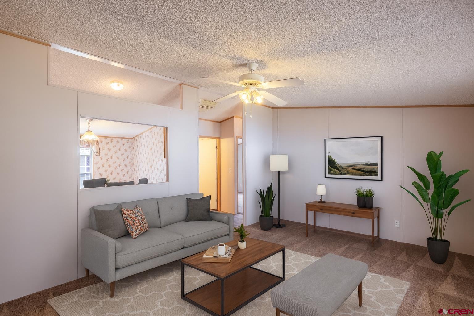 901 6530 Road, Unit 1203 Montrose, CO 81401 - Photo 3 of 22 a living room with furniture a chandelier and a window