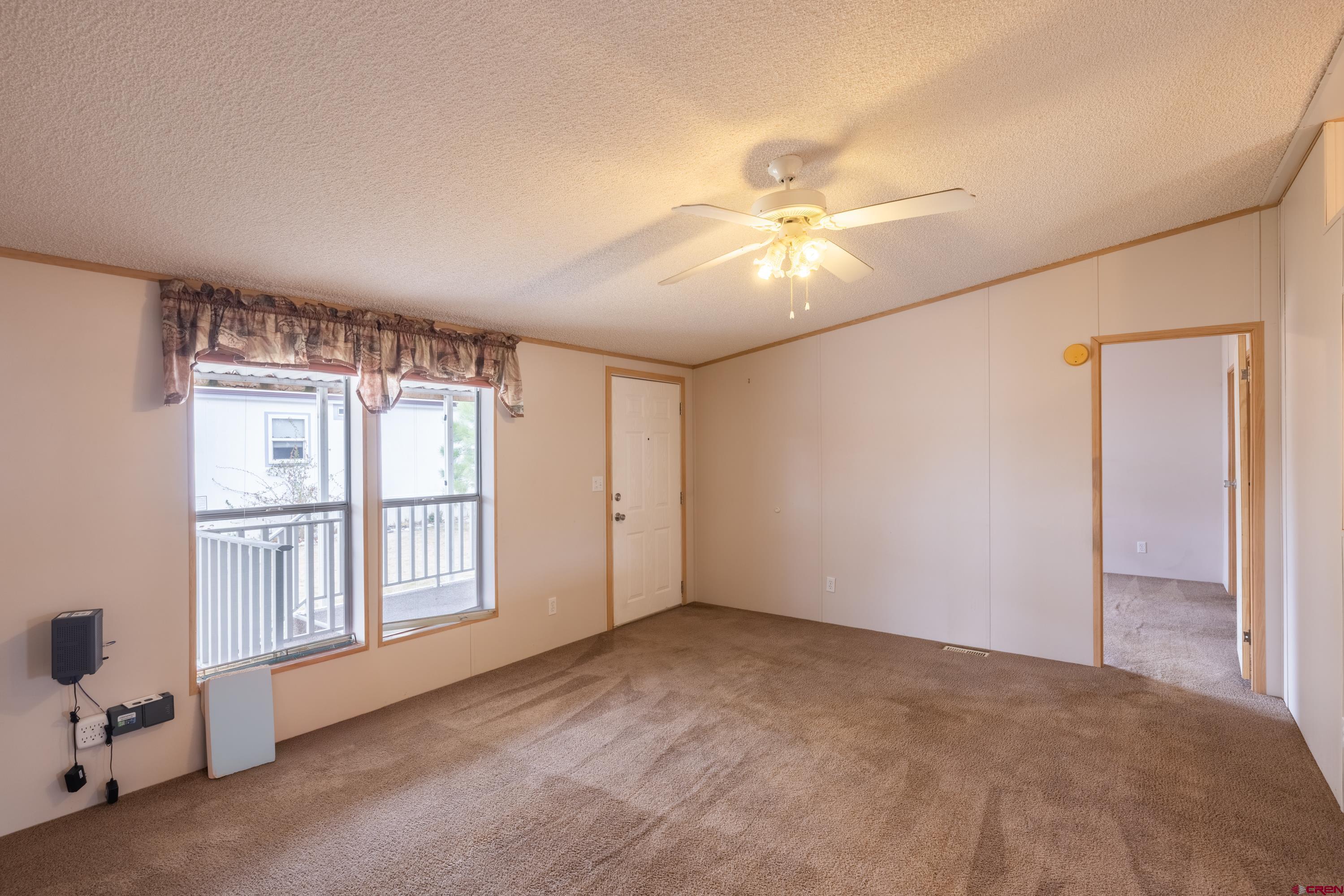 901 6530 Road, Unit 1203 Montrose, CO 81401 - Photo 4 of 22 a view of a livingroom with a ceiling fan and window