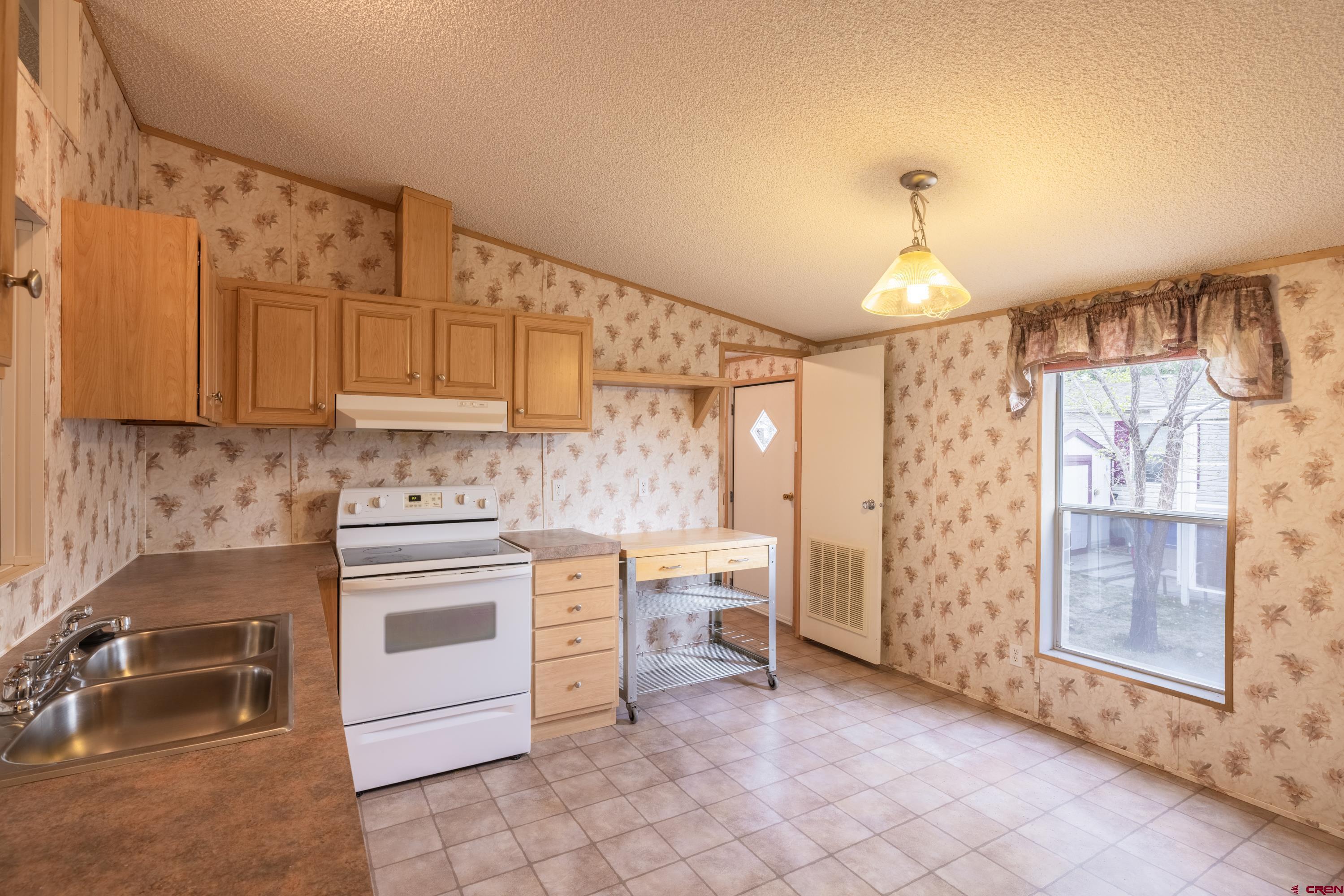 901 6530 Road, Unit 1203 Montrose, CO 81401 - Photo 6 of 22 a kitchen with granite countertop a sink and a stove