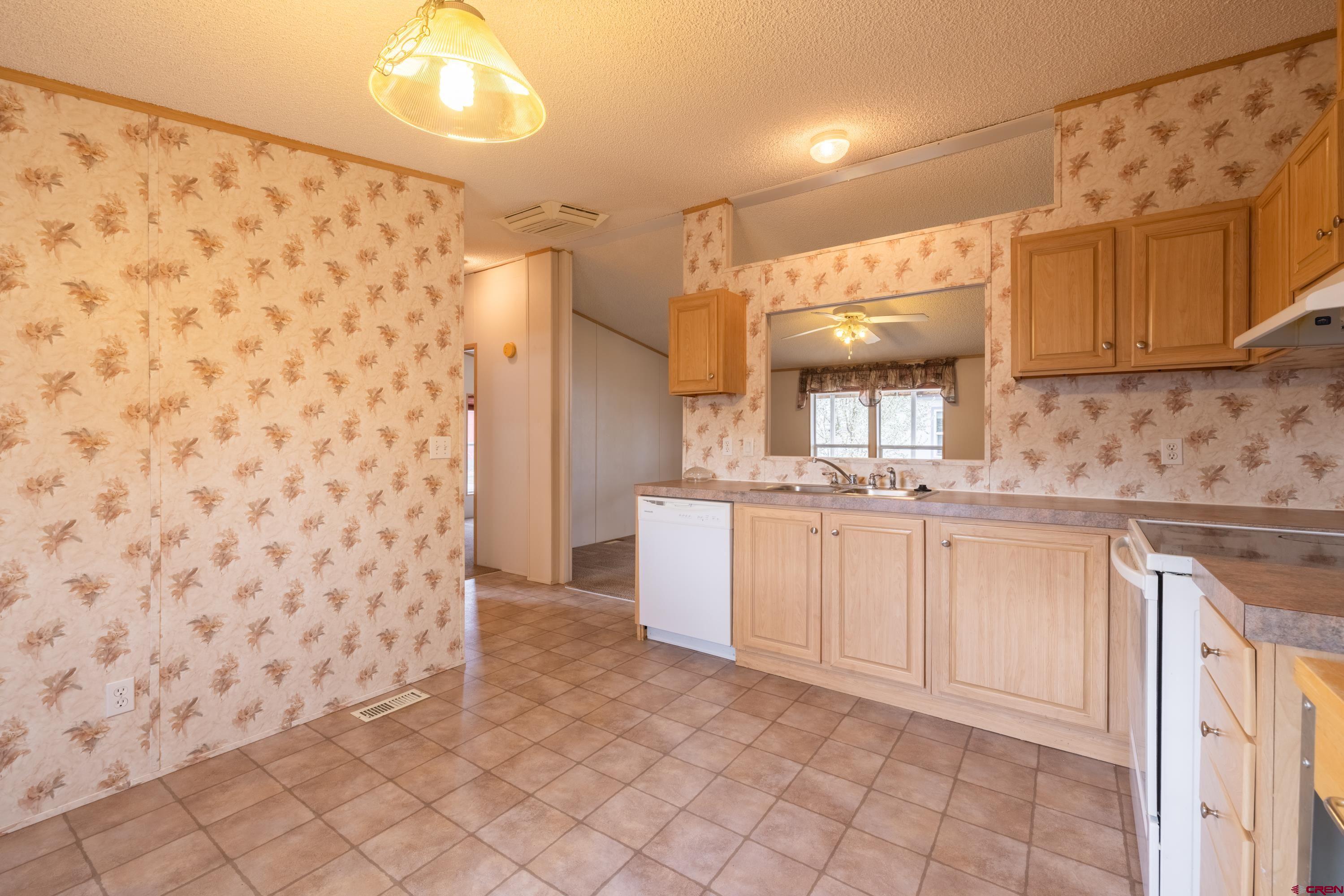 901 6530 Road, Unit 1203 Montrose, CO 81401 - Photo 8 of 22 a kitchen with white cabinets and sink