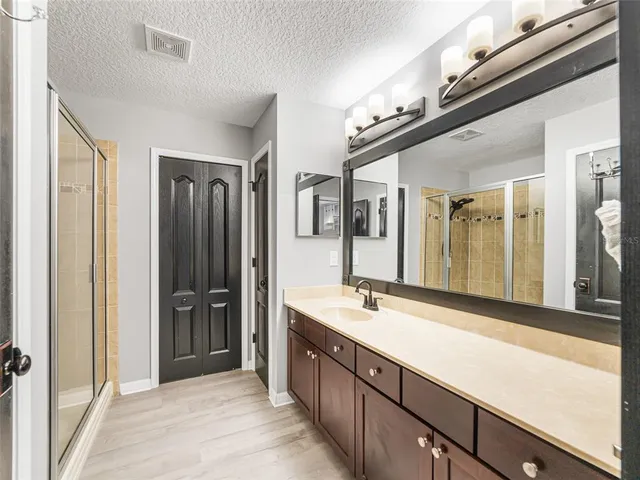 a bathroom with a granite countertop sink mirror and shower