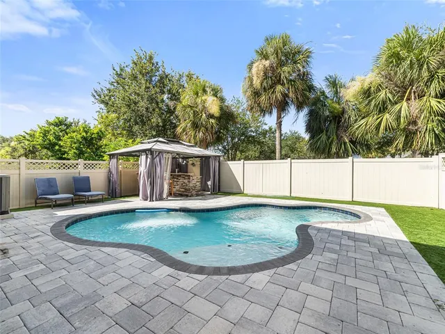 a swimming pool with outdoor seating yard and barbeque oven