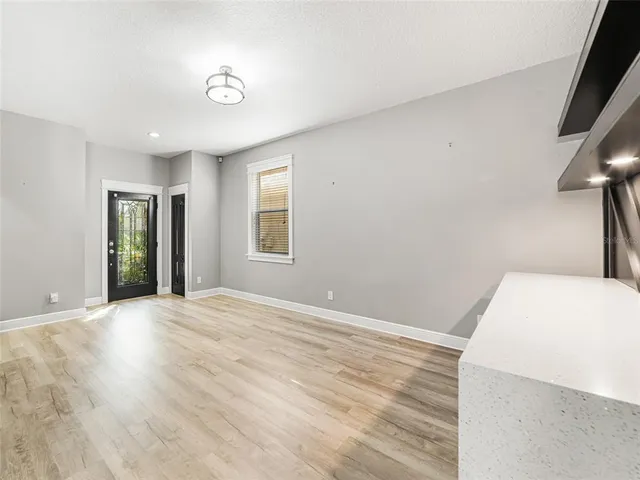 a view of an empty room with closet and a window