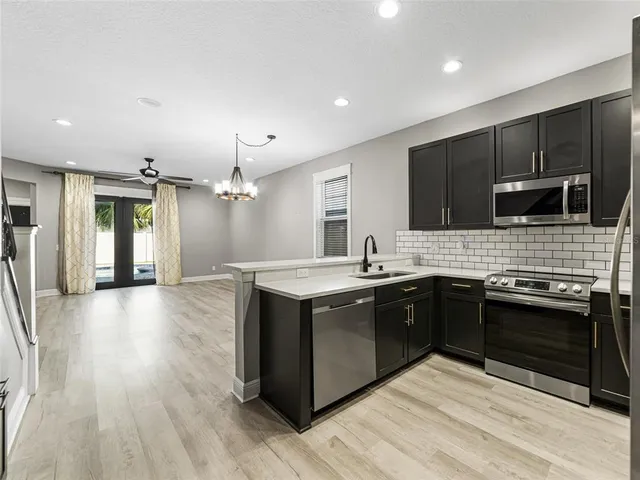 a large kitchen with stainless steel appliances granite countertop a stove and a sink