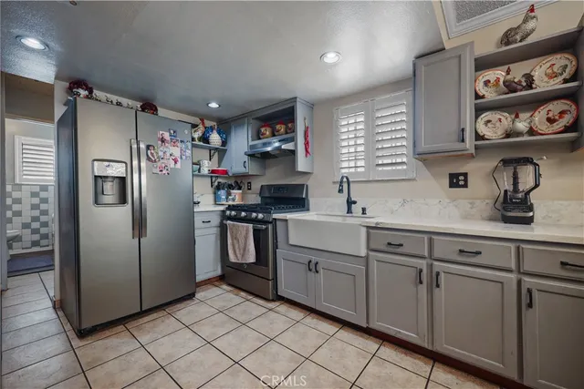 a kitchen with white cabinets a refrigerator and a sink