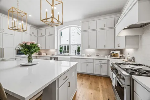 a kitchen with granite countertop a sink stainless steel appliances and white cabinets
