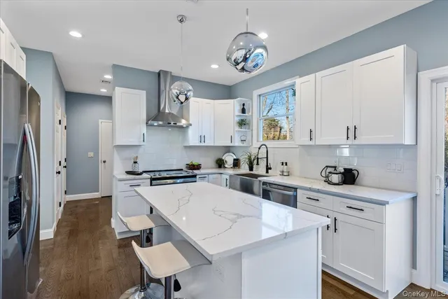 a kitchen with stainless steel appliances granite countertop a sink a stove a refrigerator and cabinets