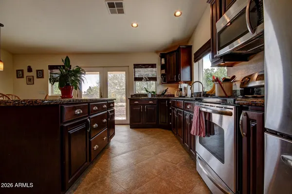 a kitchen with stainless steel appliances granite countertop a stove a sink and a refrigerator