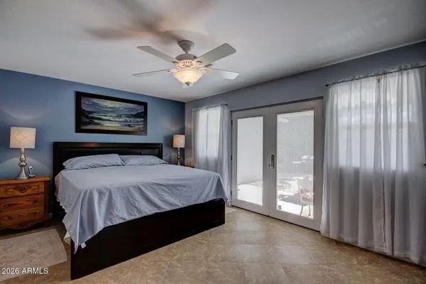 a spacious bedroom with a large bed and a chandelier