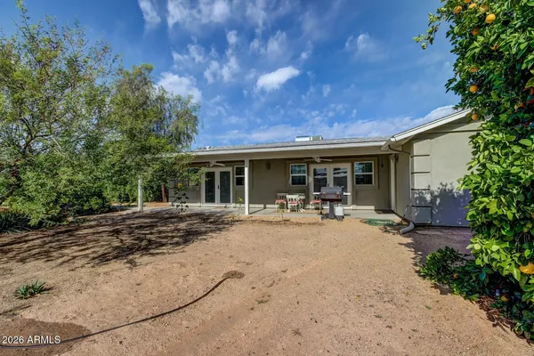 a view of a house with backyard sitting area and garden