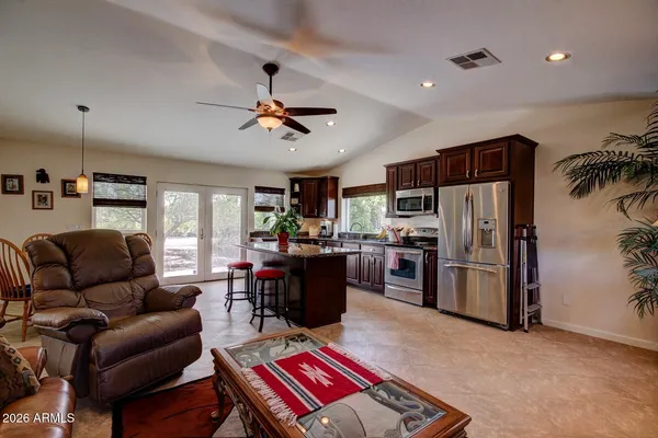 a living room with furniture a kitchen and a refrigerator