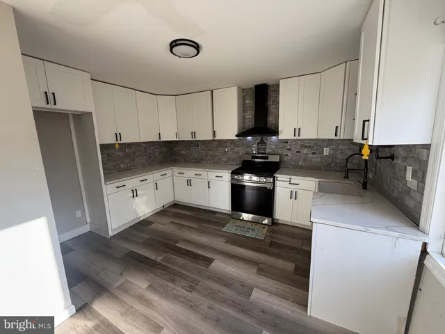 a kitchen with granite countertop a sink a stove and refrigerator