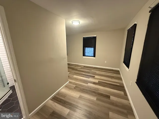 a view of a hallway with wooden floor and a window