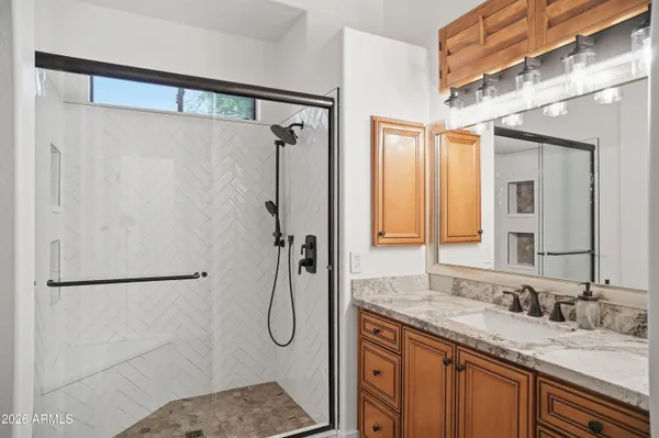 a bathroom with a granite countertop shower sink and mirror