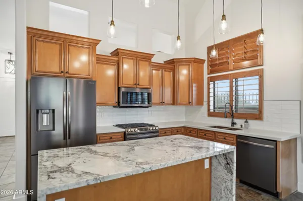 a kitchen with stainless steel appliances granite countertop a sink refrigerator and microwave