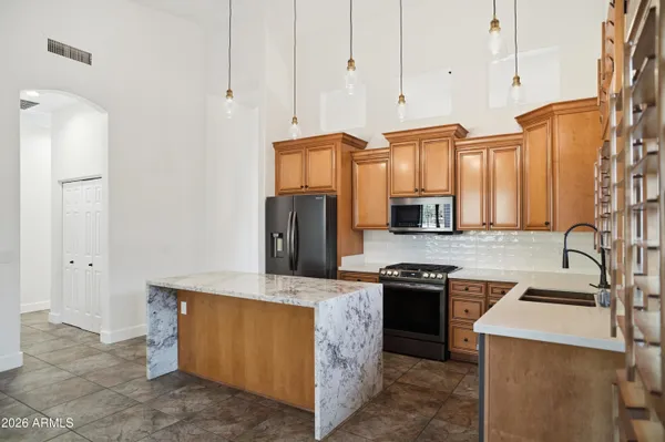 a kitchen with stainless steel appliances granite countertop a stove a sink and a refrigerator