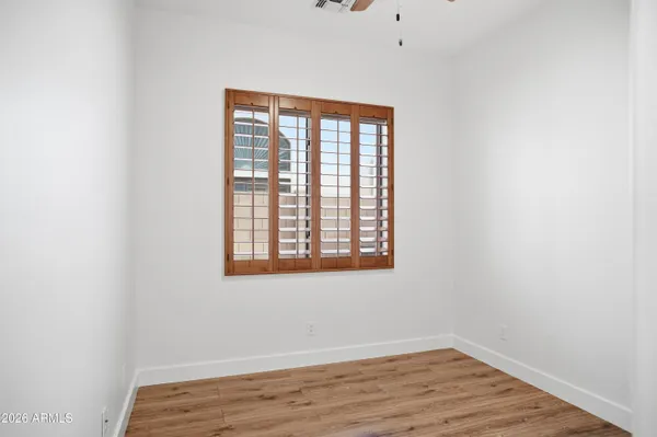 an empty room with wooden floor and a window