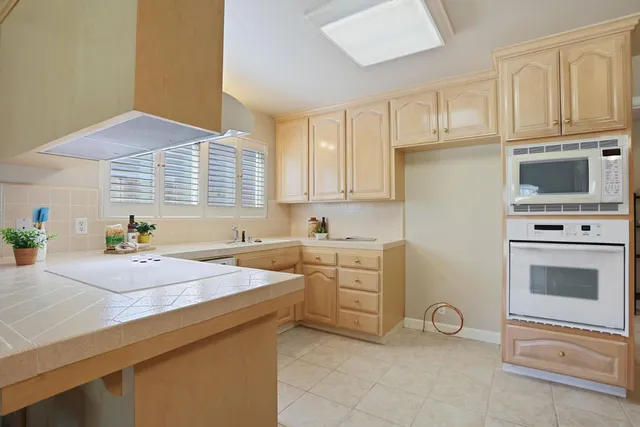 a kitchen with granite countertop a sink stainless steel appliances and cabinets