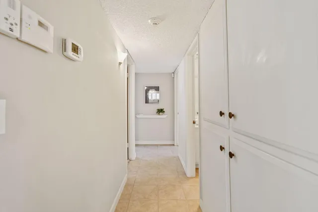 a view of a hallway with wooden floor and a bathroom