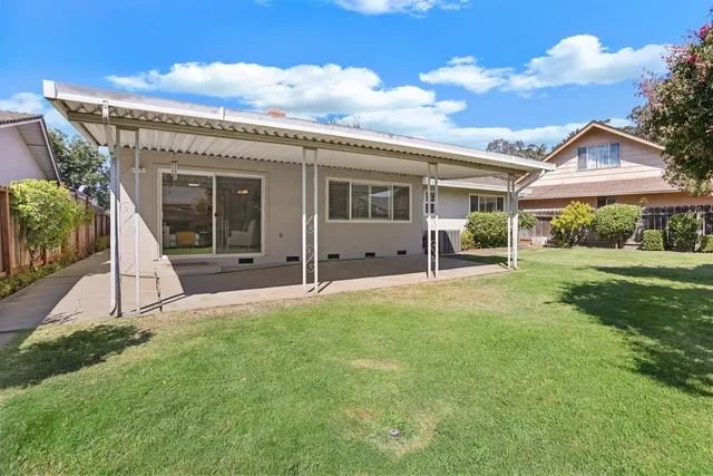 a view of a house with backyard and porch