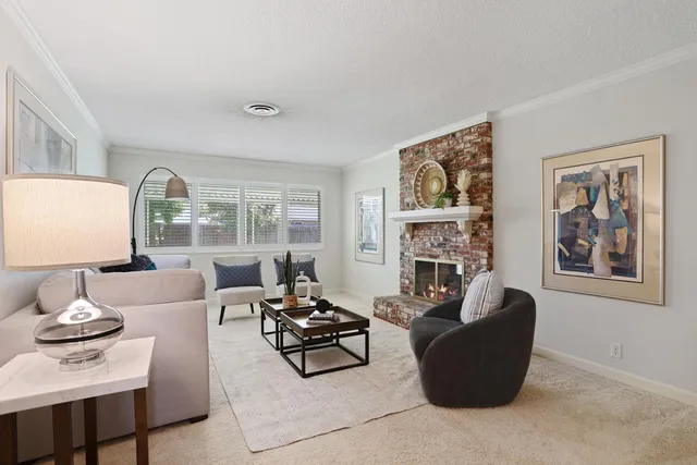 a living room with furniture fireplace and a large window
