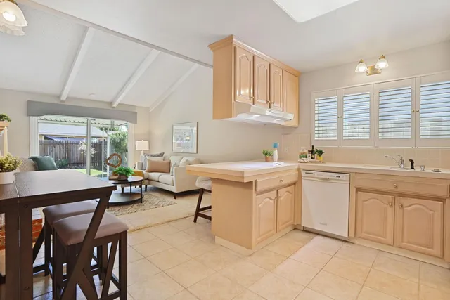 a kitchen with sink cabinets and dining table chair