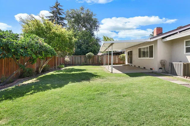 a backyard of a house with table and chairs