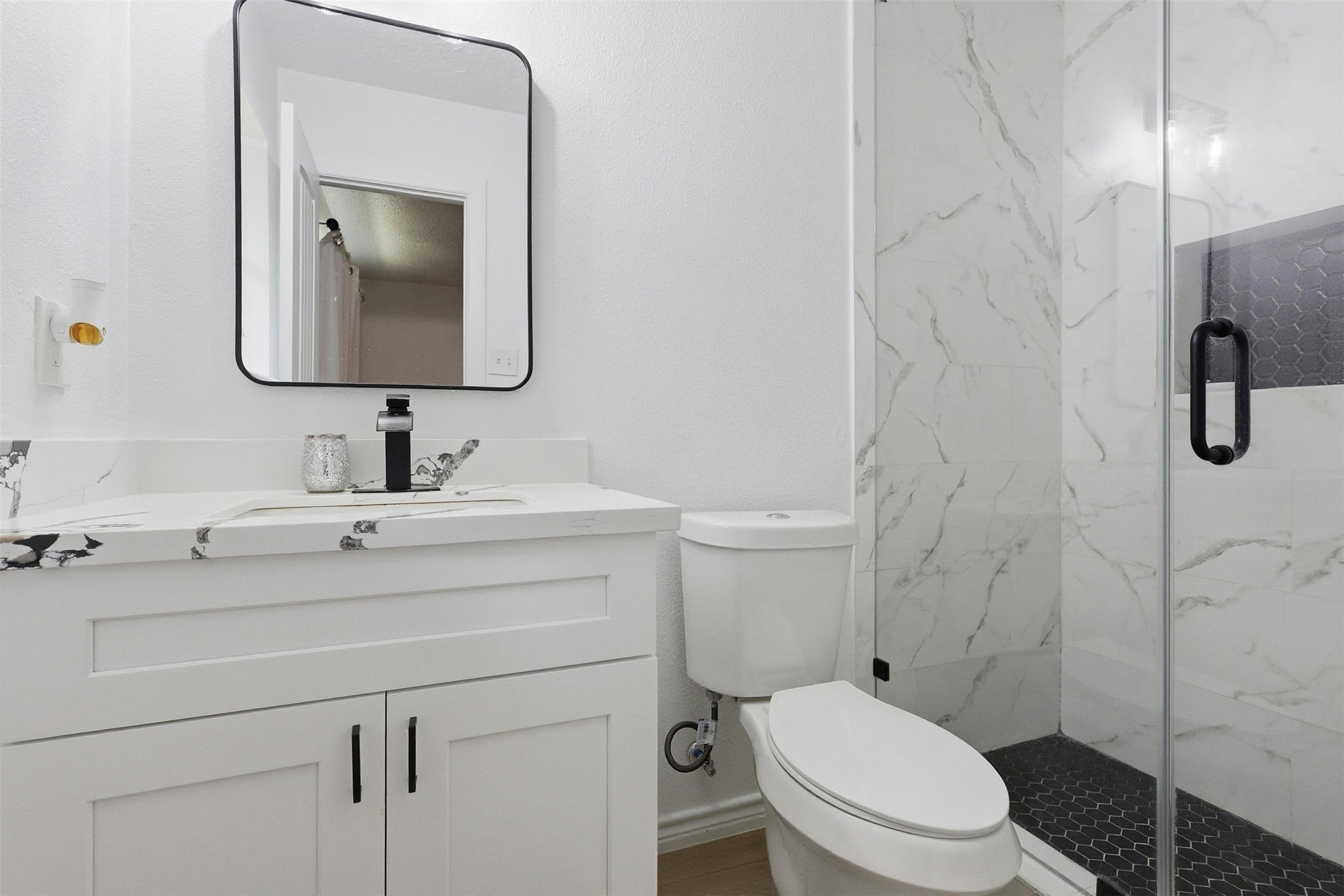 23310 Dew Wood Lane Spring, TX 77373 - Photo 4 of 24 Modern primary bath featuring designer tile, quartz vanity, and chic black accents.