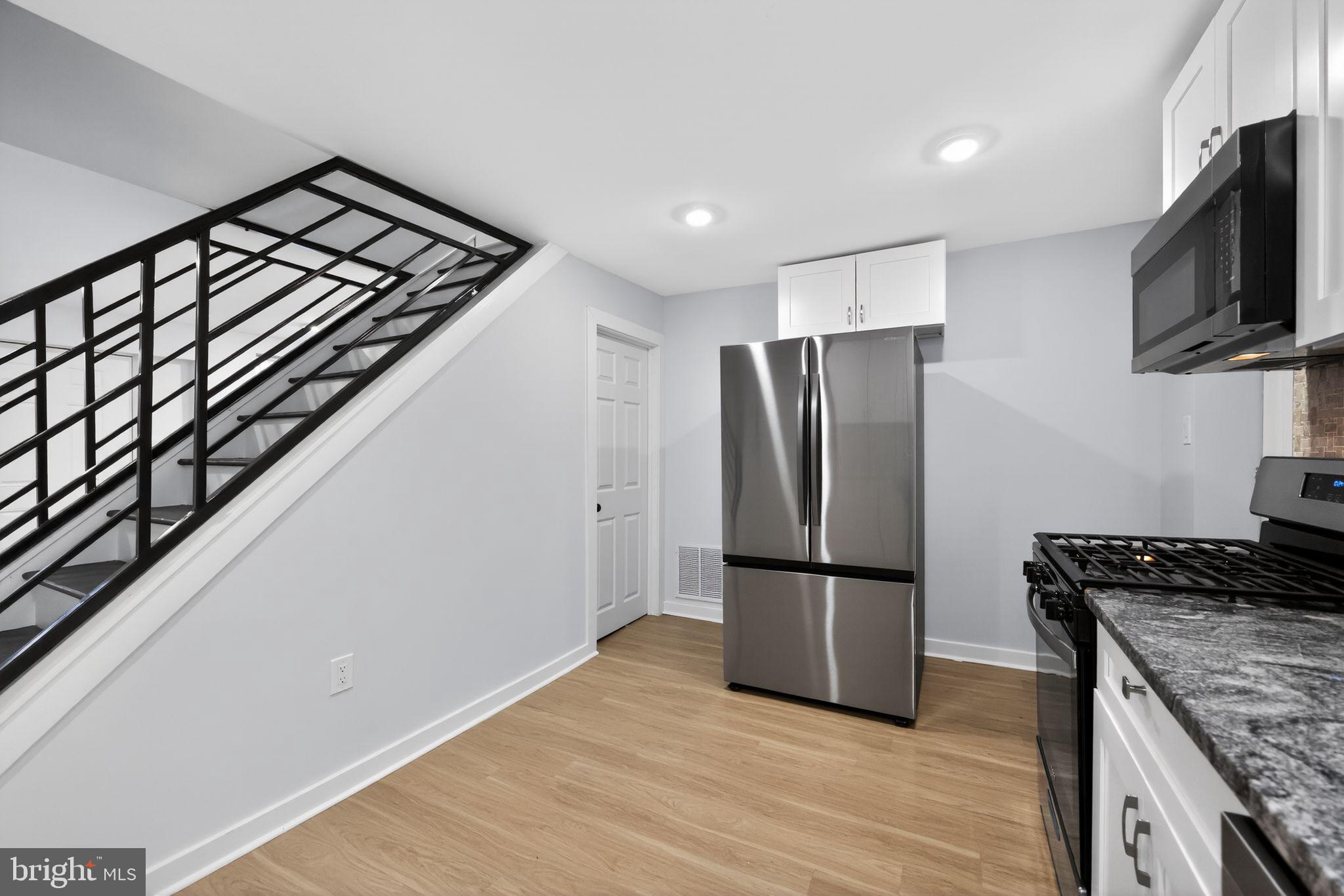 3055 Kearsarge Road Camden, NJ 08104 - Photo 6 of 26 a kitchen with a refrigerator a stove and wooden floor