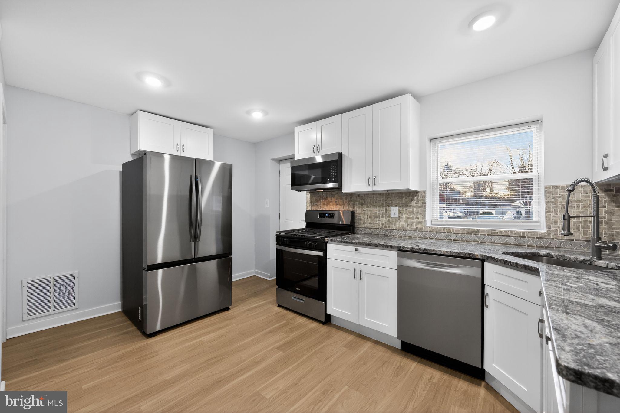 3055 Kearsarge Road Camden, NJ 08104 - Photo 9 of 26 a kitchen with granite countertop a refrigerator stove top oven and sink