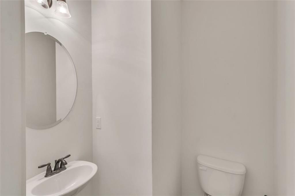 1563 Butternut Cove Stone Mountain, GA 30083 - Photo 14 of 35 a bathroom with a toilet sink and mirror