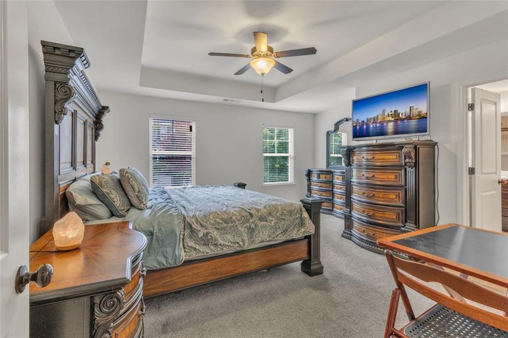 1563 Butternut Cove Stone Mountain, GA 30083 - Photo 17 of 35 a bedroom with a bed and a chandelier