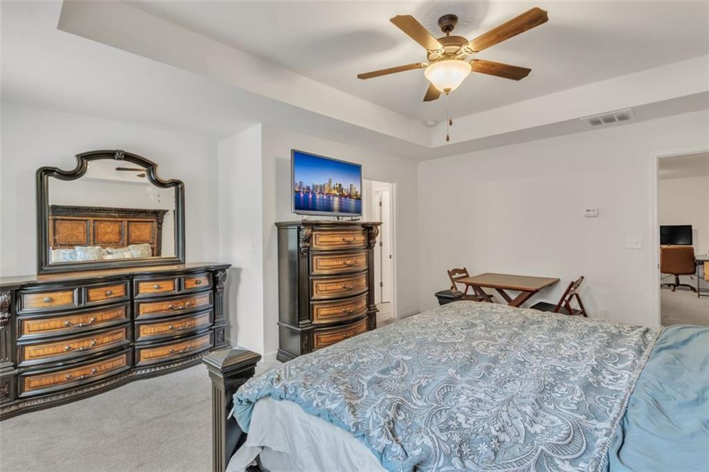 1563 Butternut Cove Stone Mountain, GA 30083 - Photo 19 of 35 a bedroom with a bed and a chandelier