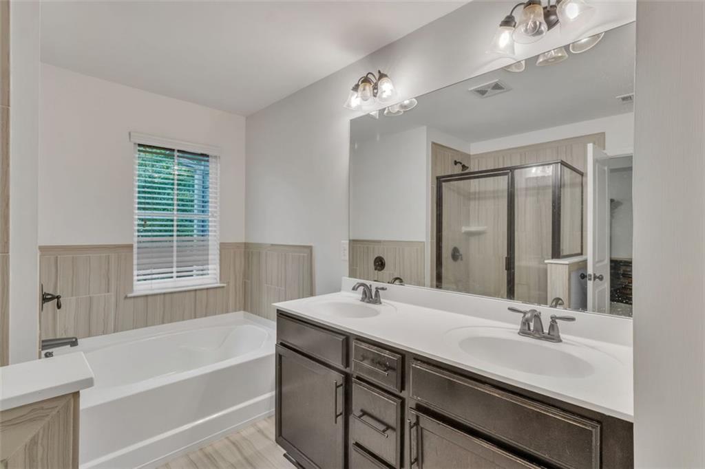 1563 Butternut Cove Stone Mountain, GA 30083 - Photo 23 of 35 a bathroom with a tub double sink and mirror