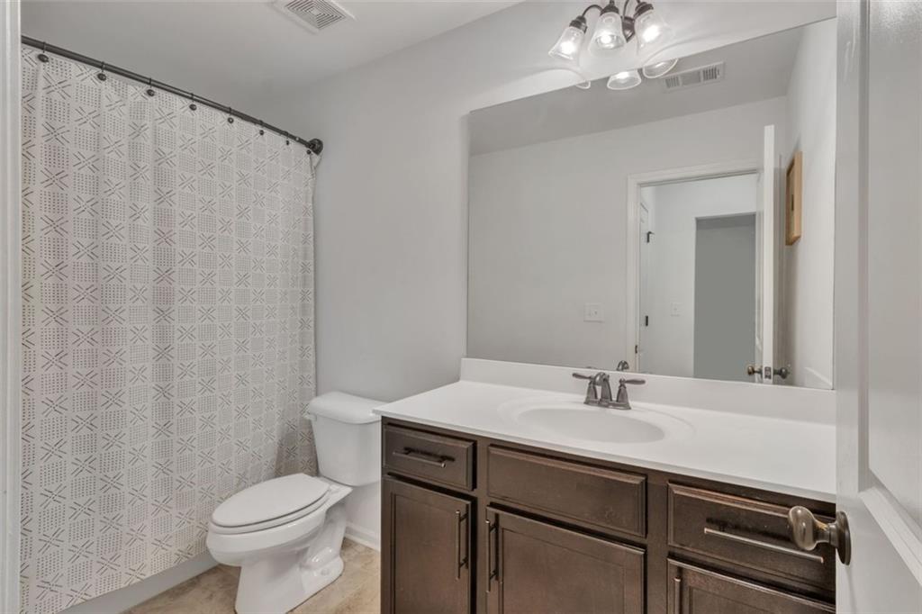 1563 Butternut Cove Stone Mountain, GA 30083 - Photo 25 of 35 a bathroom with a sink vanity mirror and toilet