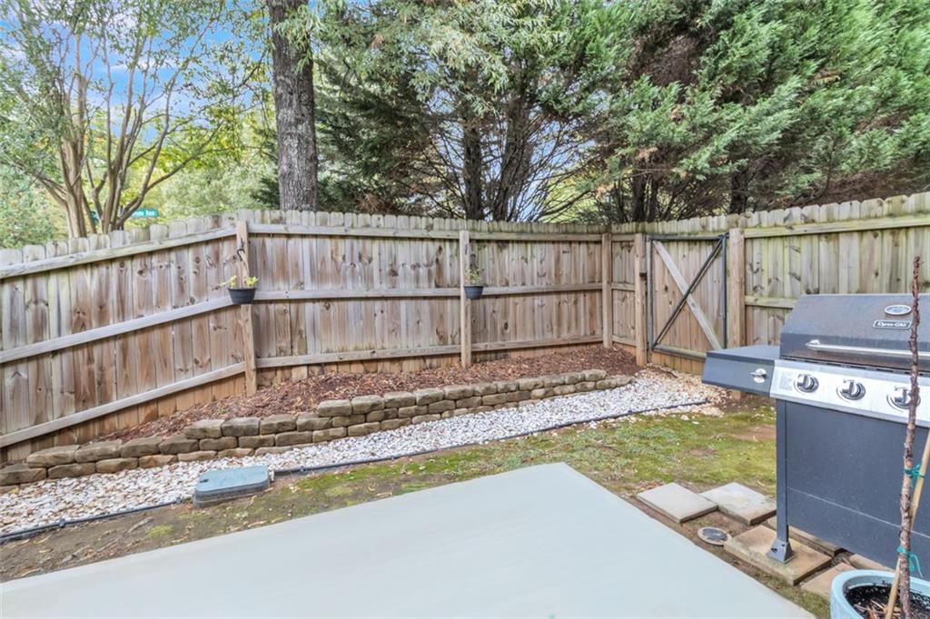1563 Butternut Cove Stone Mountain, GA 30083 - Photo 29 of 35 a view of a backyard with a large tree and wooden fence