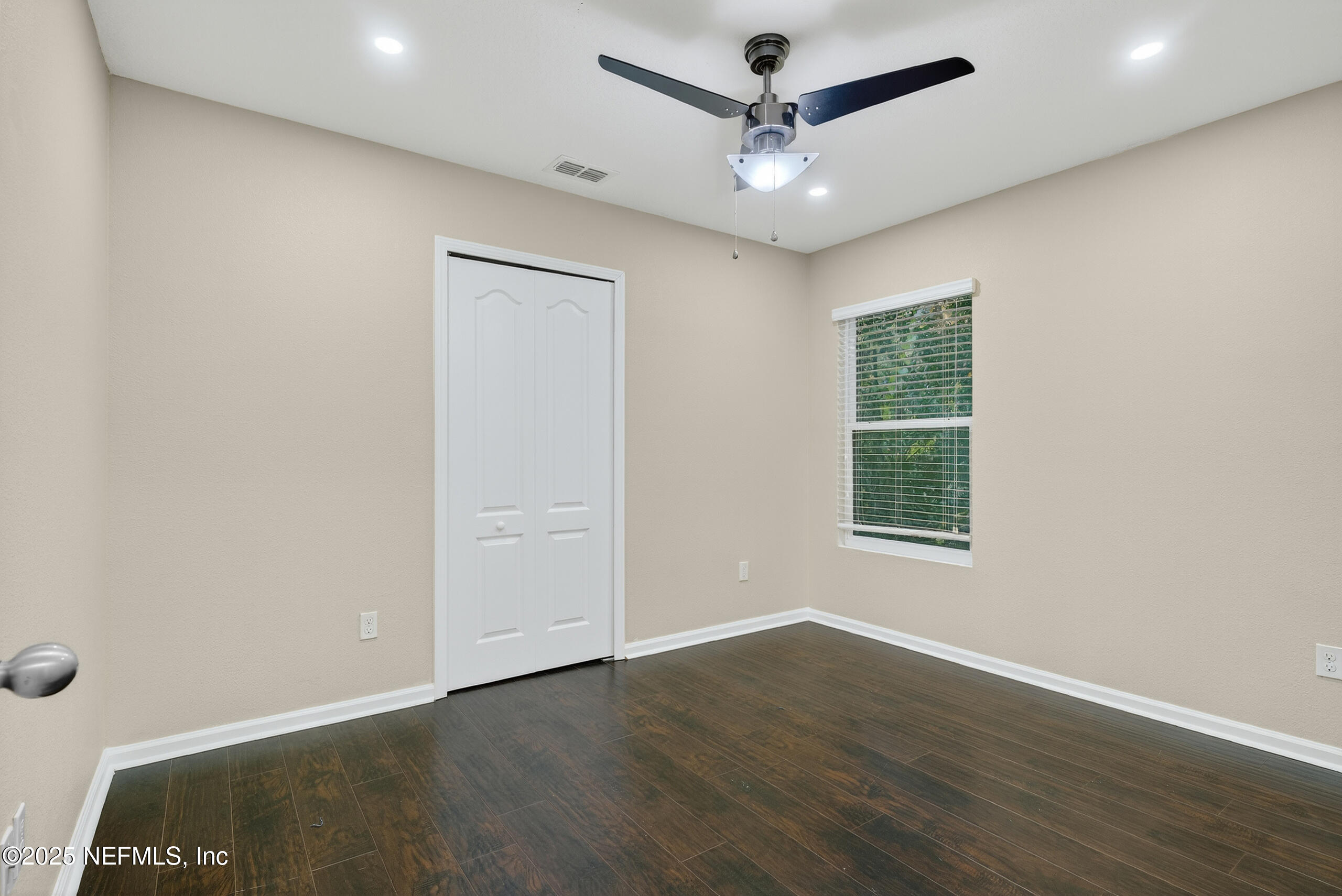 15885 Bainebridge Drive Jacksonville, FL 32218 - Photo 20 of 46 an empty room with wooden floor ceiling fan and windows