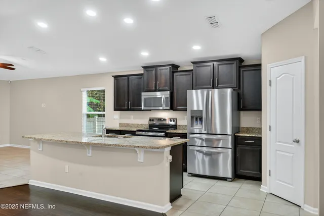 a kitchen with granite countertop a refrigerator a stove and a sink
