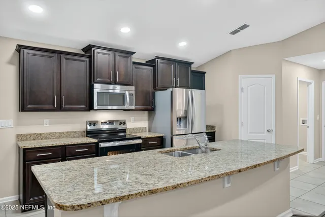 a kitchen with stainless steel appliances granite countertop a sink and a stove
