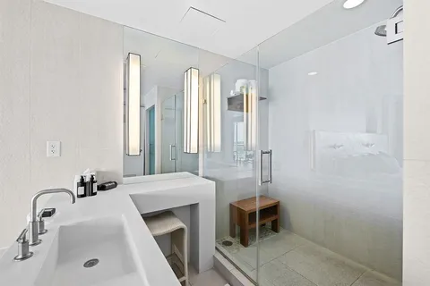 a bathroom with a double vanity sink a toilet and a tub