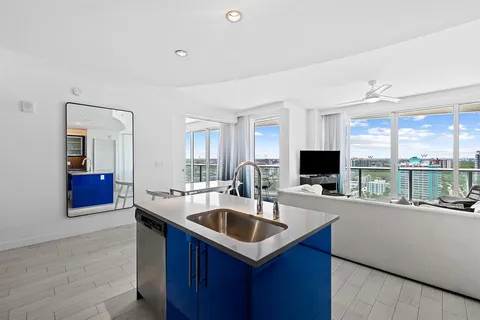 a kitchen with a sink and a stove top oven with wooden floor