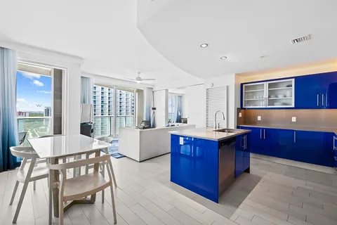 a living room with stainless steel appliances granite countertop a couch and a wooden cabinets