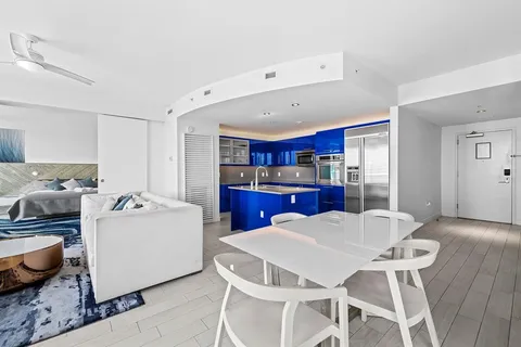 a kitchen with kitchen island a stove a table and chairs in it