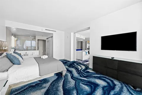 a bedroom with a bed and a flat screen tv