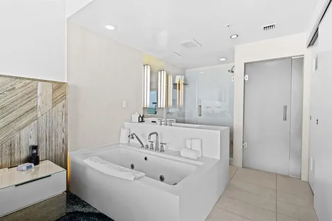 a spacious bathroom with a tub sink and mirror