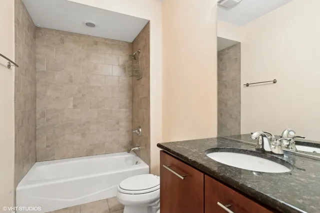 a bathroom with a granite countertop sink toilet and shower