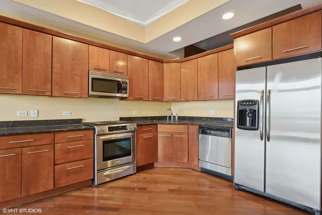 a kitchen with stainless steel appliances granite countertop a stove a sink dishwasher a refrigerator and a microwave oven